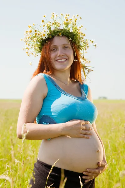 Беременная женщина на летнем лугу — стоковое фото