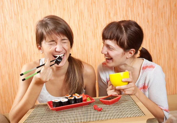 Boldog nők étkezési sushi tekercs — Stock Fotó