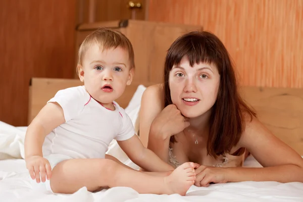 Madre con bambino su lenzuolo bianco — Foto Stock
