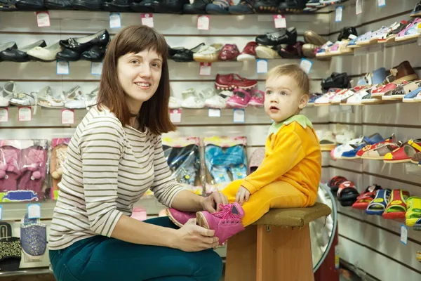 Kvinna med barn väljer Babyskor — Stockfoto