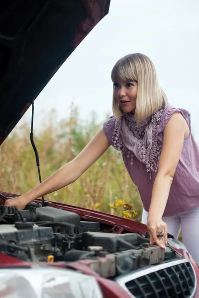 Женщина пытается починить машину. — стоковое фото