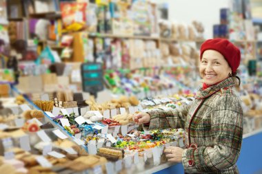 Mature woman chooses sweets clipart