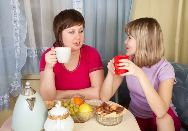 两个女孩说长道短，喝喝茶 — 图库照片