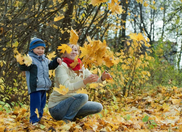 Matka z chłopiec rzuca liście klonu — Zdjęcie stockowe