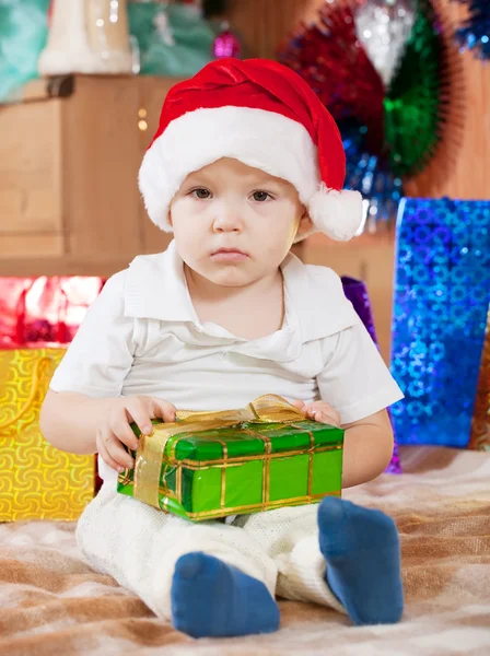 Menino senta-se com presente de Natal — Fotografia de Stock