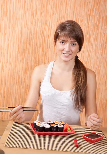 Mulher comendo rolos de sushi — Fotografia de Stock