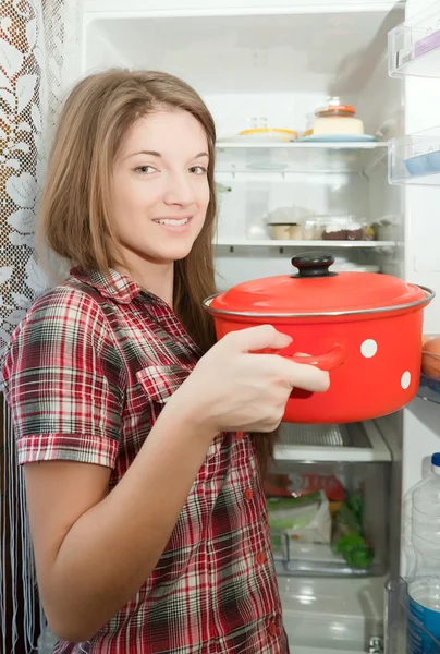 Girl putting pan into refrigerator — Stock Photo, Image
