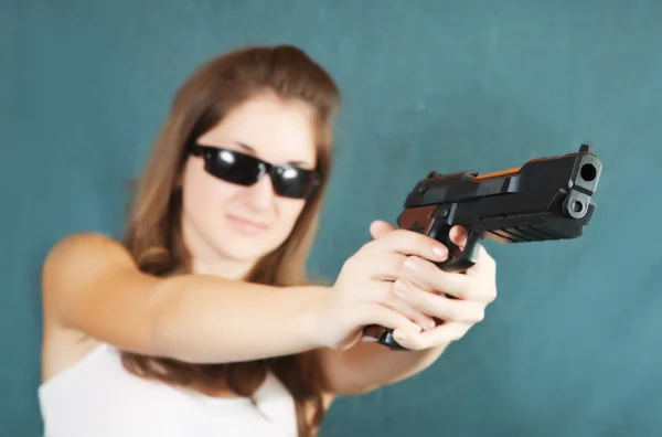 Girl aiming a black gun — Stock Photo, Image