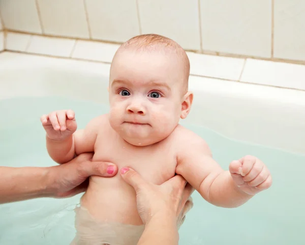 Baby swimming on mother 's hands — стоковое фото