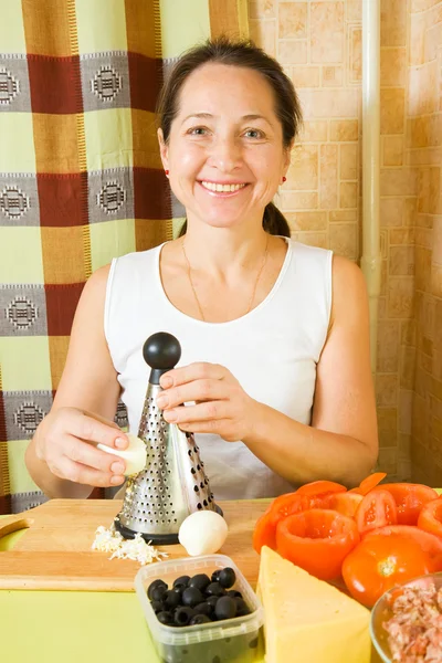 Woman grating eggs in her kitchen — Stock Photo, Image