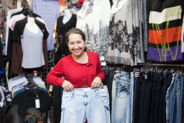 Mogen kvinna väljer jeans — Stockfoto