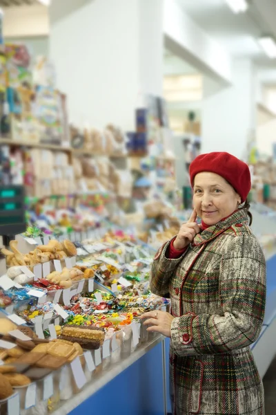 stock image Mature woman chooses sweets