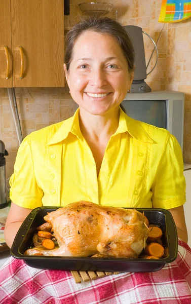 Woman with cooked stuffed chicken — Stockfoto