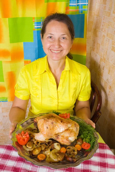 Woman serving baked chicken on tray — Stock Photo, Image