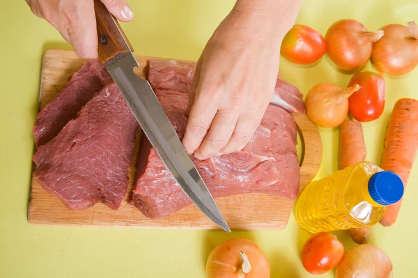 Cook hands cutting beef — Stock Photo, Image
