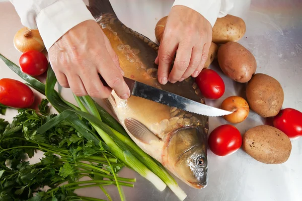 Kuchař vaření ryb kapra v kuchyni — Stock fotografie