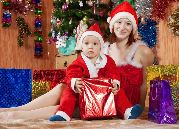 Junge gekleidet wie Weihnachtsmann mit Mutter Stockbild