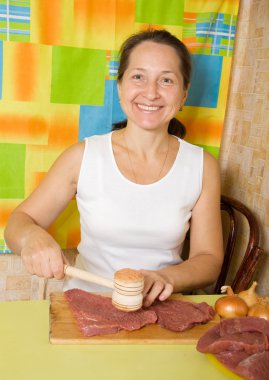 Woman making tenderized steak clipart