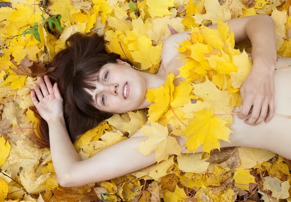 Naken tjej i lönn löv — Stockfoto