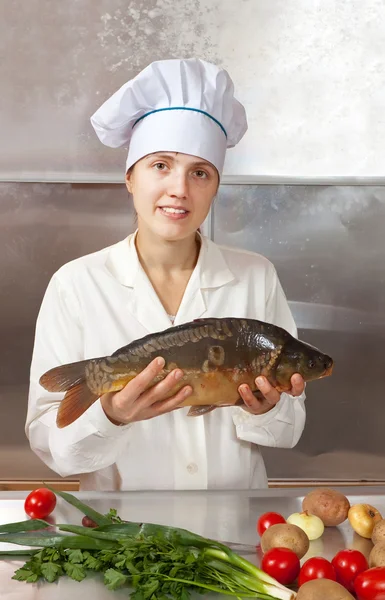 Femme cuisinière avec poisson carpe — Photo