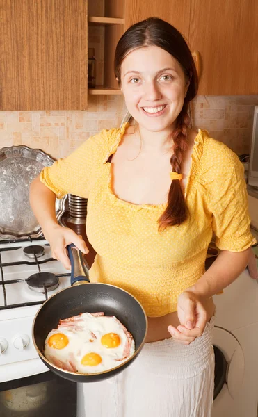 Νεαρή γυναίκα με τηγανητά αυγά και μπέικον — Φωτογραφία Αρχείου