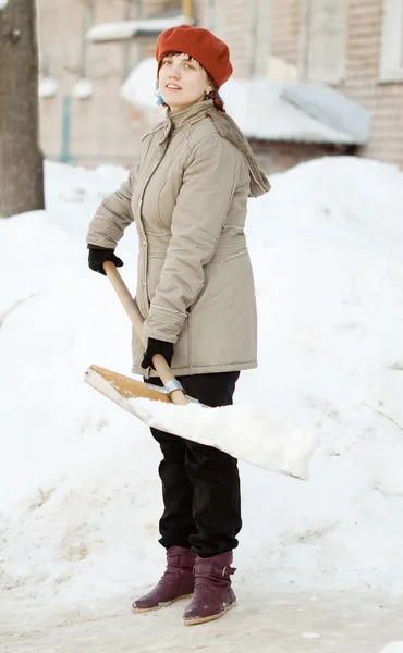 Dziewczyna rzucanie śniegiem z łopatą — Zdjęcie stockowe