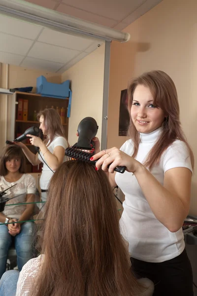 Kadeřnice pracují s vysoušečem vlasů — Stock fotografie