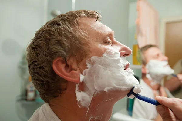 Hombre afeitándose con cuchilla de afeitar —  Fotos de Stock