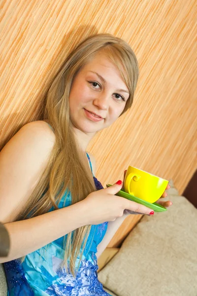 Ragazza seduta a bere caffè sul divano — Foto Stock