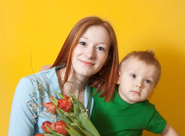 Mãe com filho sobre amarelo — Fotografia de Stock