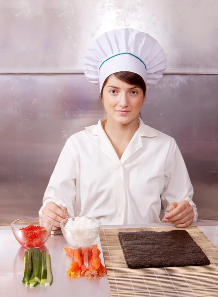 Cozinheiro mulher fazendo rolos de sushi — Fotografia de Stock