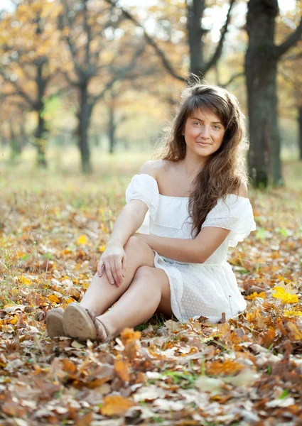 Dívka v bílých šatech na podzimní park — Stock fotografie