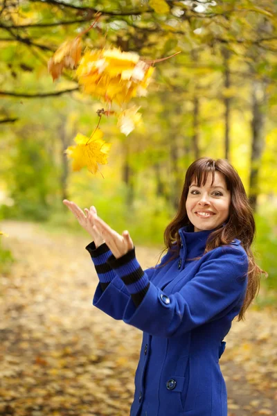 Dziewczyna rzuca liście w powietrzu — Zdjęcie stockowe