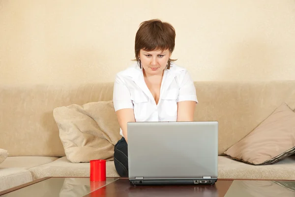 Dizüstü bilgisayar ile oturma odasında kız — Stok fotoğraf