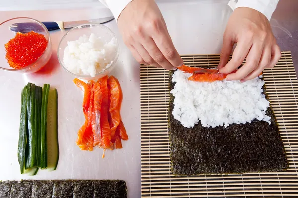 Cozinheiro fazendo rolos de sushi japonês — Fotografia de Stock