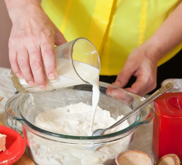 stock image Cook hands adds milk into flour