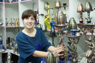 Woman chooses sheesha in shop clipart