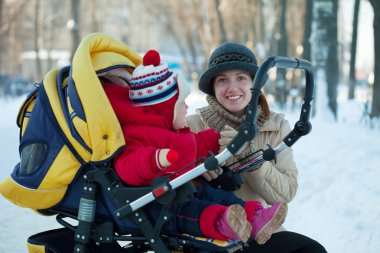 Woman with child in pram clipart