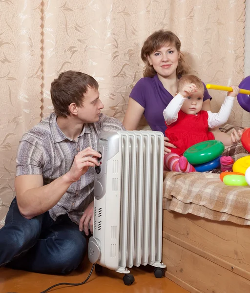 Parents and child near warm radiator — Stock Photo, Image