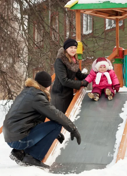 Parents with toddler playing on slide — Stock Photo, Image
