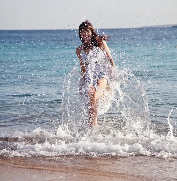 Happy woman plays at sea — Stock Photo, Image