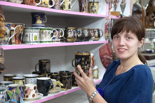 Female tourist chooses souvenir cup — Stock Photo, Image