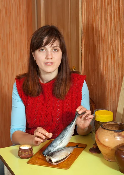 Kvinna saltning makrill fisk — Stockfoto