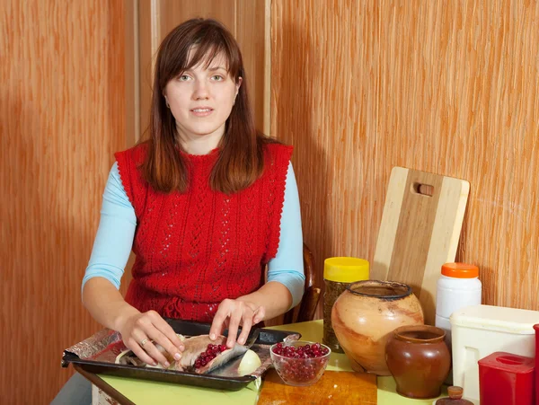Vrouw koken makreel met veenbessen — Stockfoto