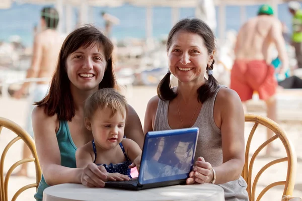 Familia feliz con portátil en el resort — Foto de Stock