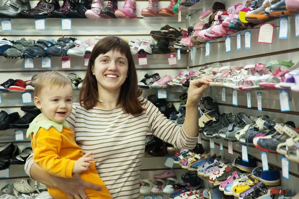 Mãe feliz com criança escolhe sapatos — Fotografia de Stock