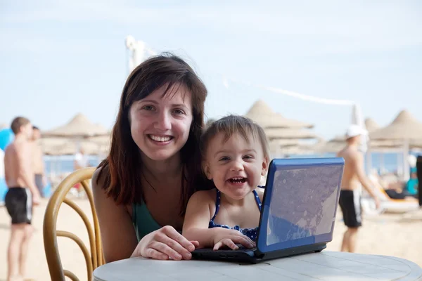 Happy family with laptop at beach — Stock Photo, Image