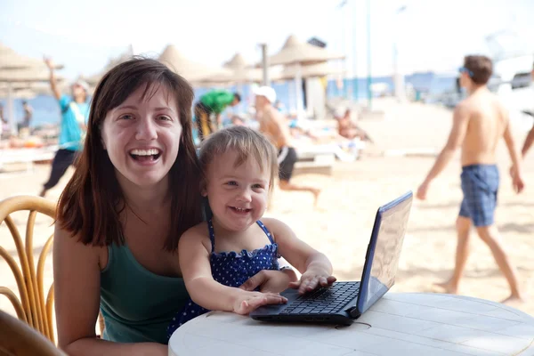 Mutlu anne ve bebek plajda laptop ile — Stok fotoğraf
