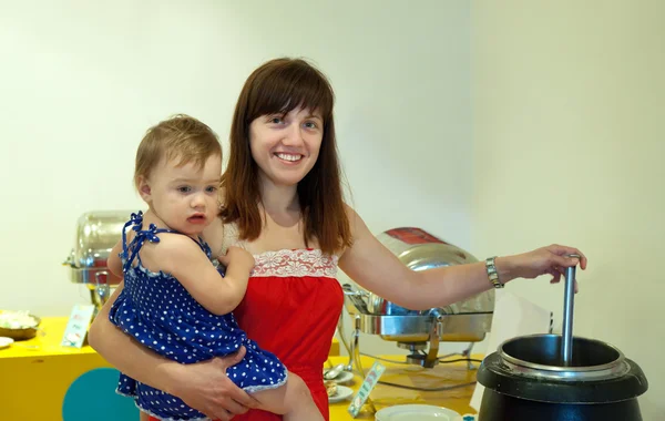 Kobieta z dzieckiem nalewania zupy — Zdjęcie stockowe