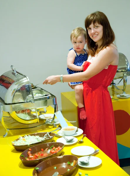 Femme avec enfant au buffet — Photo